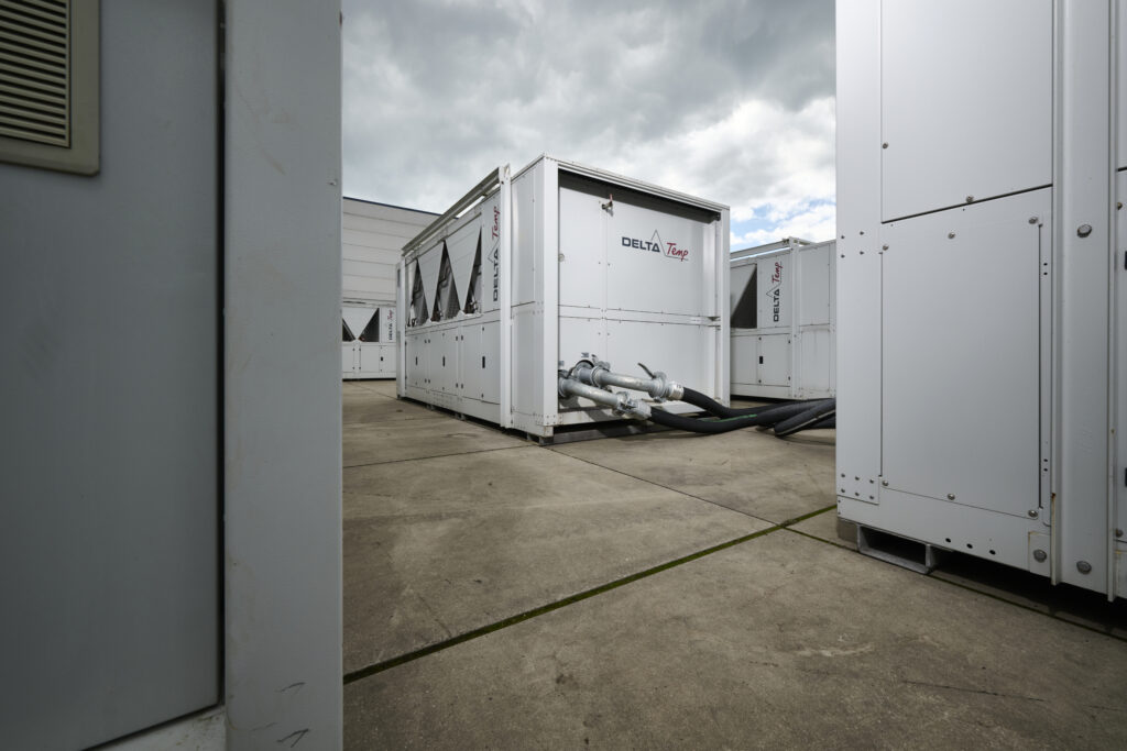 Delta-temp industriële koelunits op betonnen ondergrond onder bewolkte hemel, exemplificerend verhuurapparatuur.